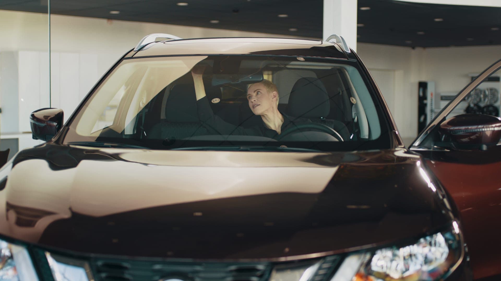 Woman smiling in new car at dealership