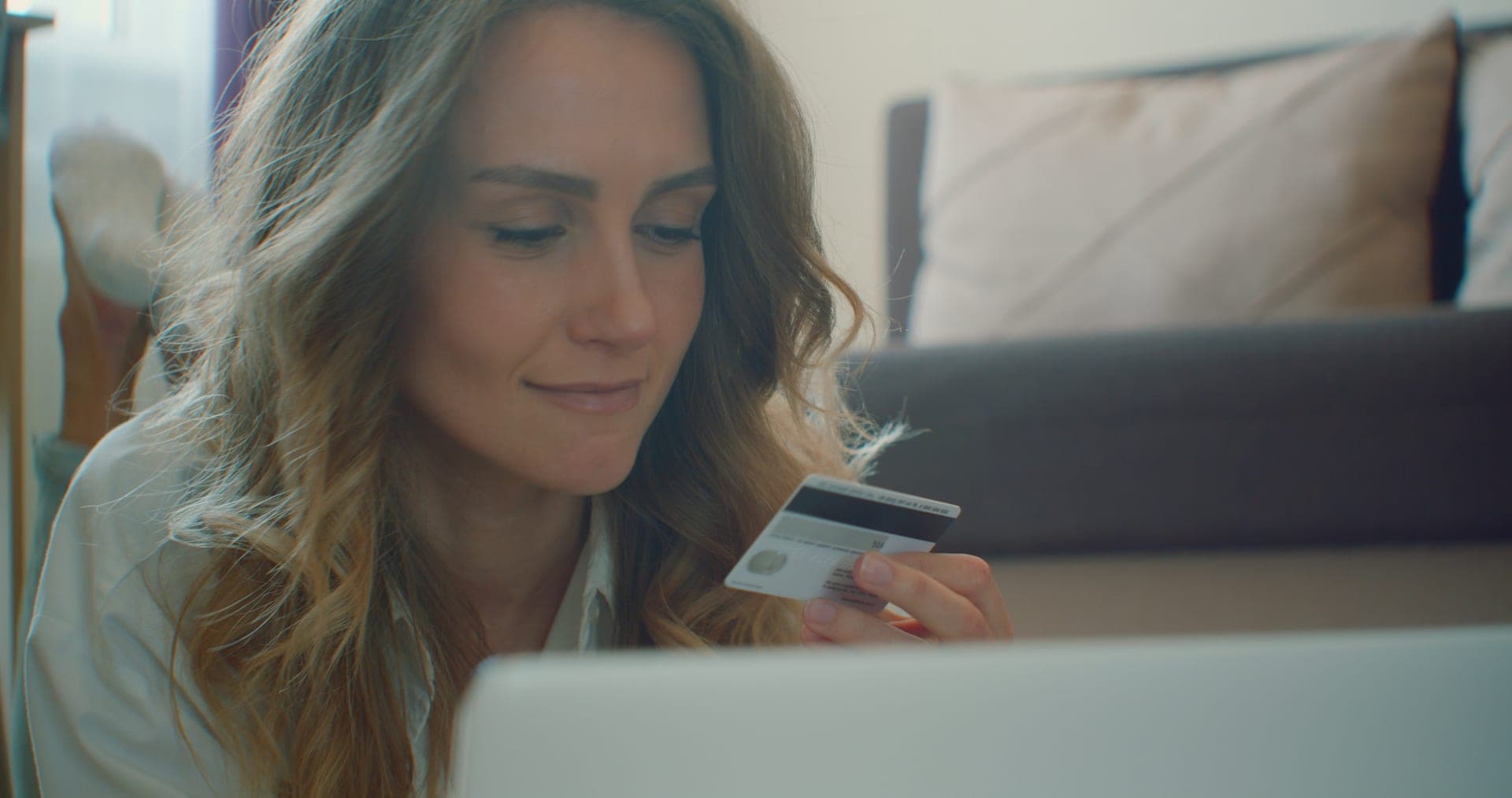 Woman using laptop with credit card for online banking