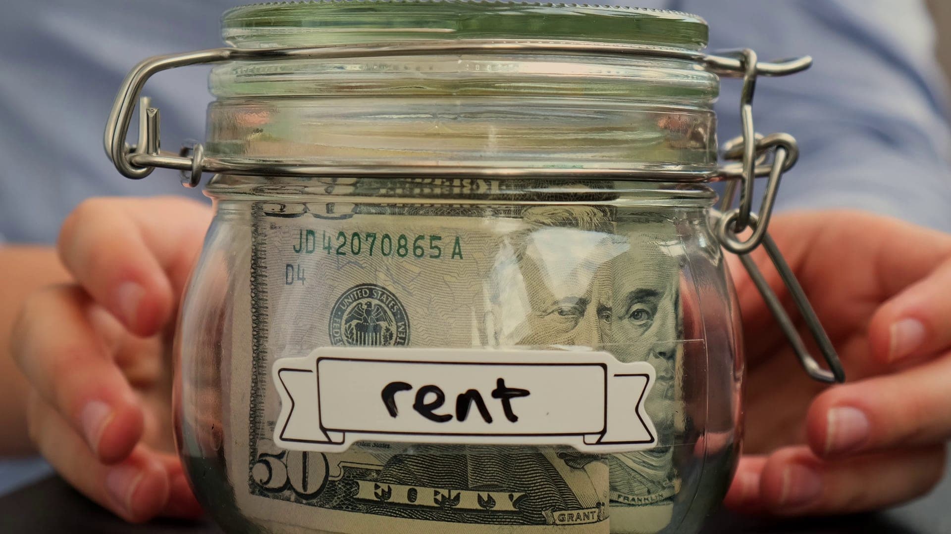 Woman putting money in savings jar
