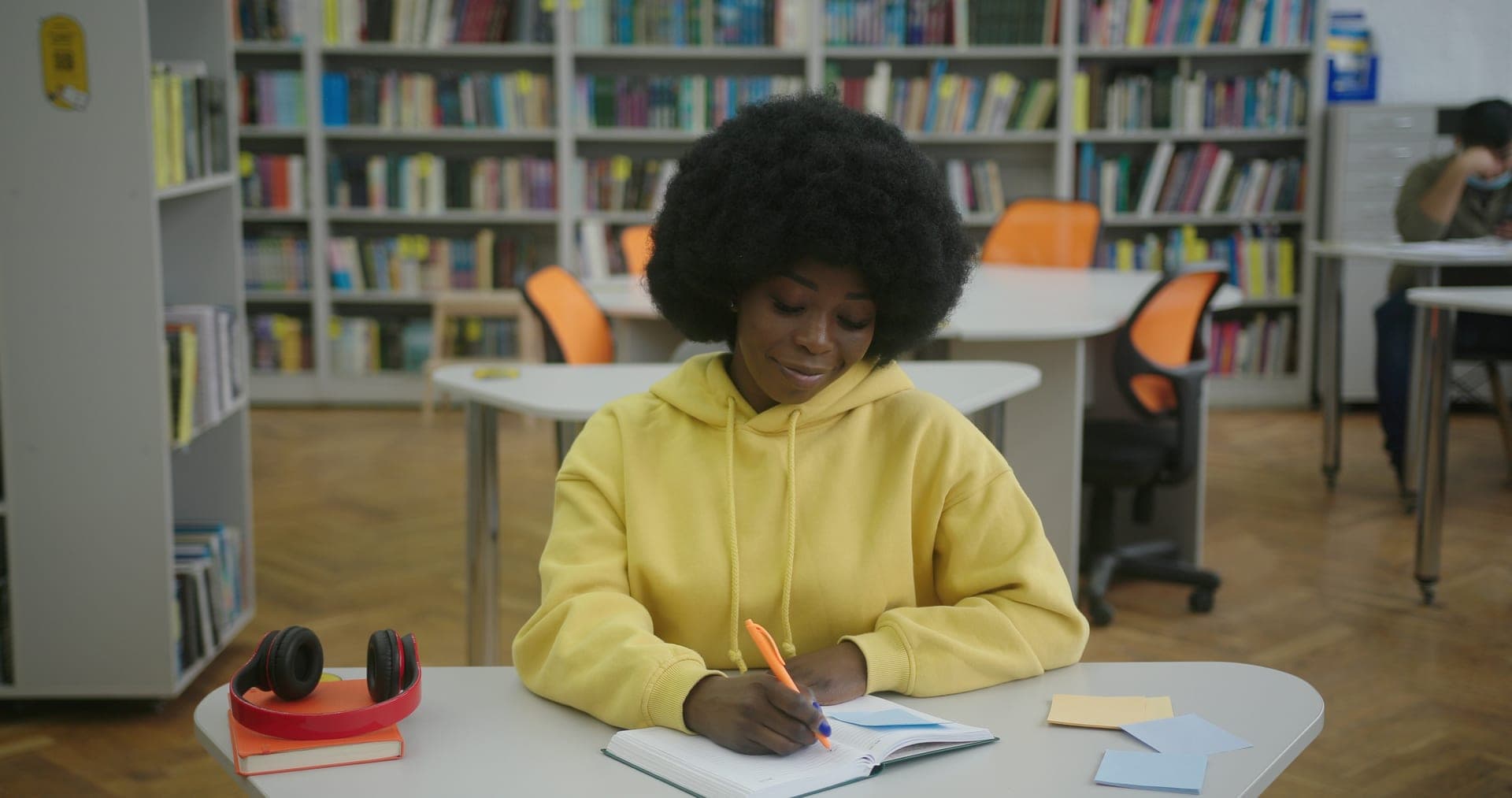 Young woman writing financial goals in a notepad
